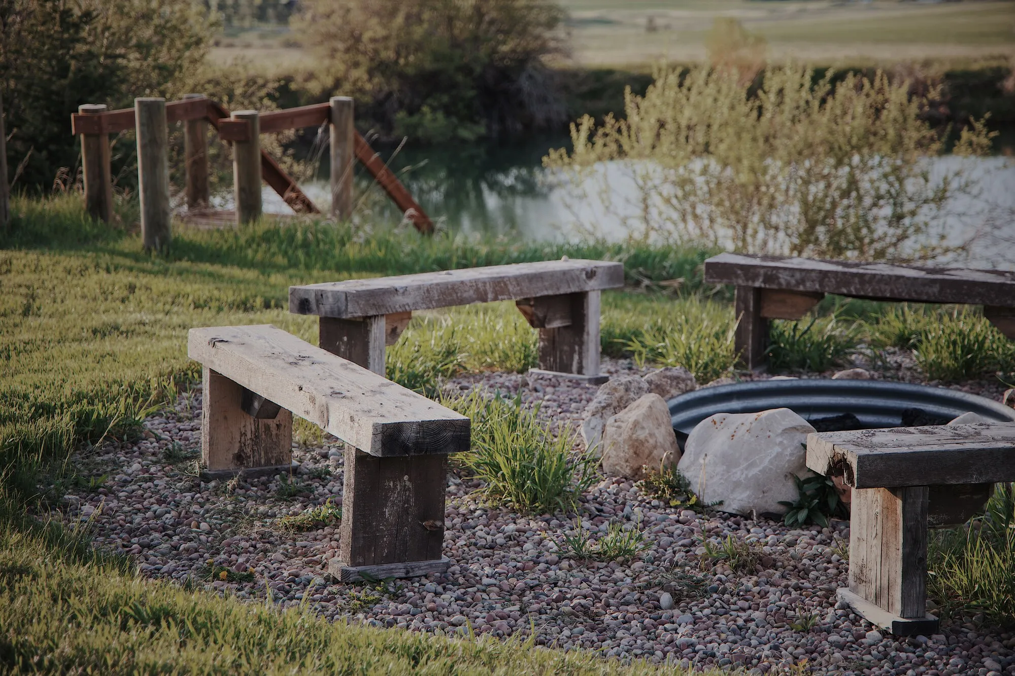 Timber benches around the fire ring near the pond