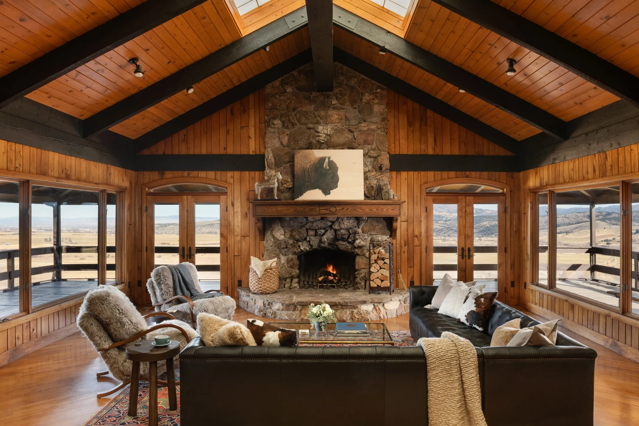 Great room: stone fireplace under the vaulted timber ceiling
